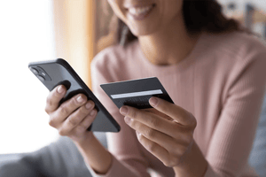 Woman in video call on mobile holding credit card